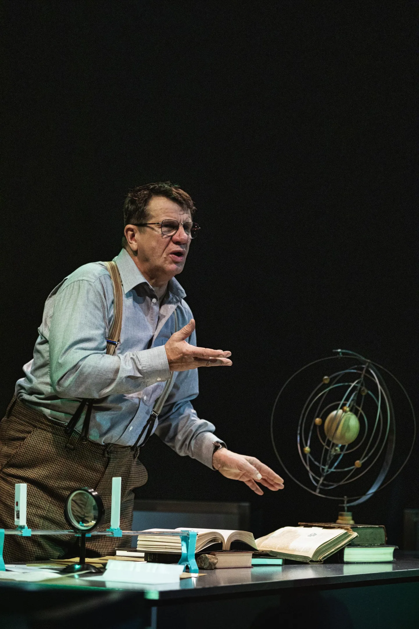 Hannes Kaljujärv Galileo Galilei rollis. Tema ees laual on mudel taevakehade liikumise selgitamiseks.