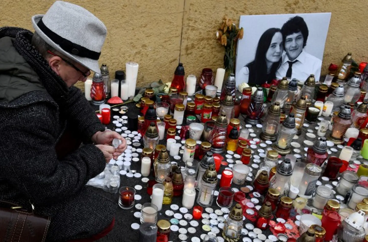 Cilvēks Bratislavā aizdedz sveci, pieminot slovāku žurnālista Jāna Kucjaka un viņa draudzenes Martinas Kušnirovas nogalināšanu.