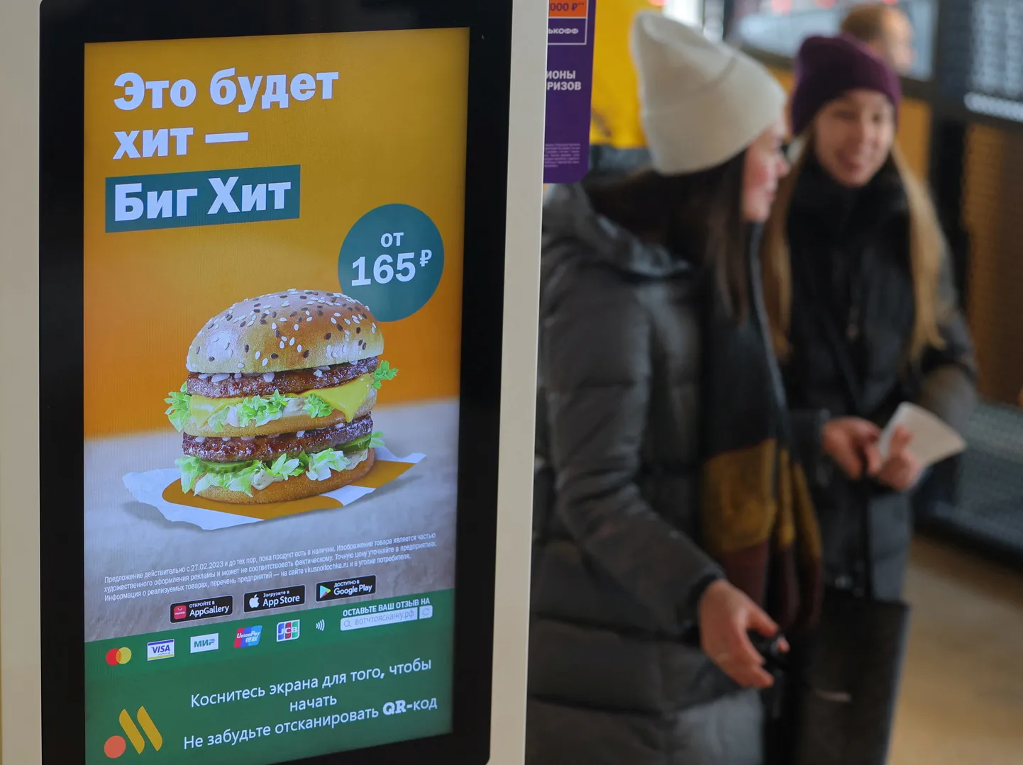 Inimesed kõnnivad iseteeninduskioski lähedal, mis reklaamib Big Hiti burgerit, uut alternatiivi Big Macile kiirtoidurestorani ketis Vkusno & tochka, mis on McDonald'si järeltulijabränd Venemaal. Moskva, 1. märts 2023.