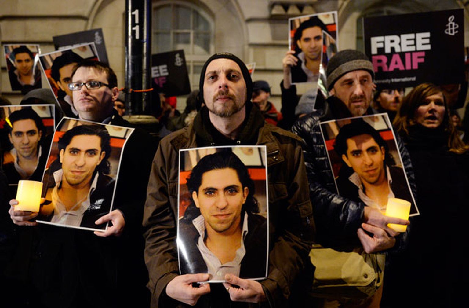 Protestētāji ar Raifa Badavi attēliem rokās