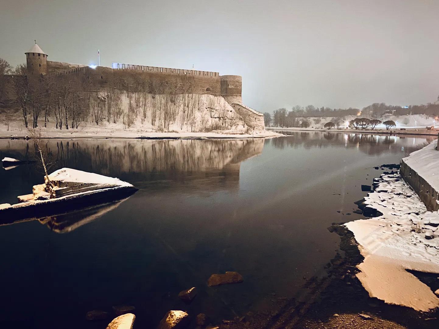 Ночной зимний вид на пограничную реку Нарва и крепость в российском Ивангороде.