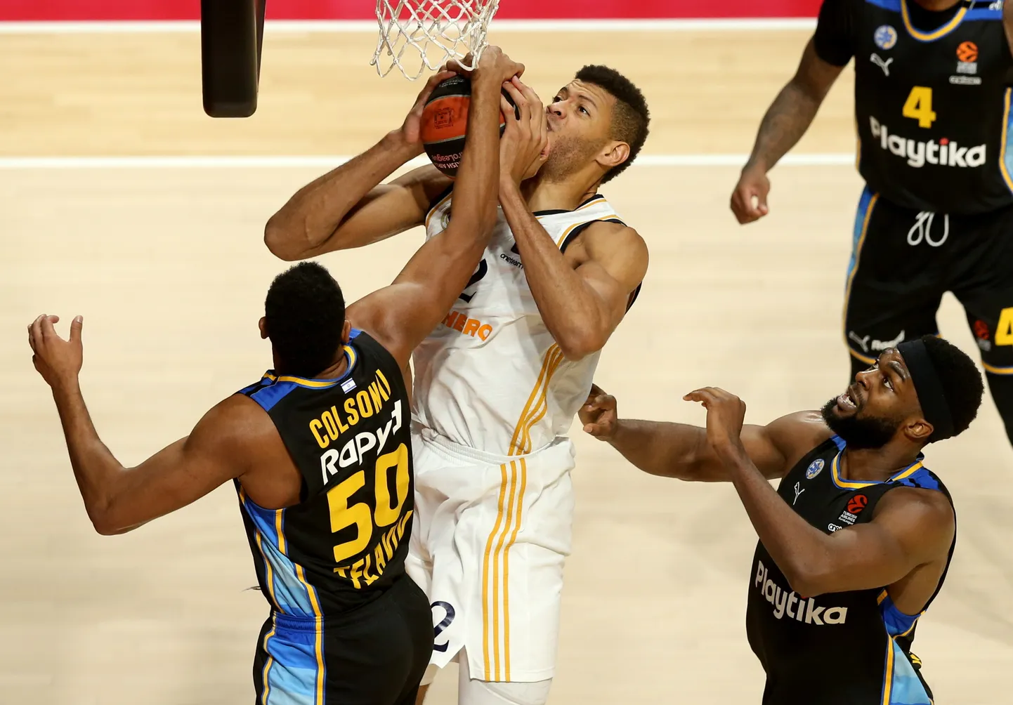 Tel Avivi Maccabi Bonzie Colson (vasakul) ja Josh Nebo (paremal) takistamas Madridi Reali koljatit Walter Tavarest (palliga).