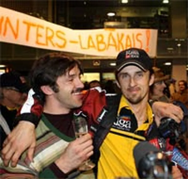 Jānis Vinters (no labās) ar brāli Dakaras rallija braucēju sagaidīšanas laikā Starptautiskajā lidostā Rīga. 