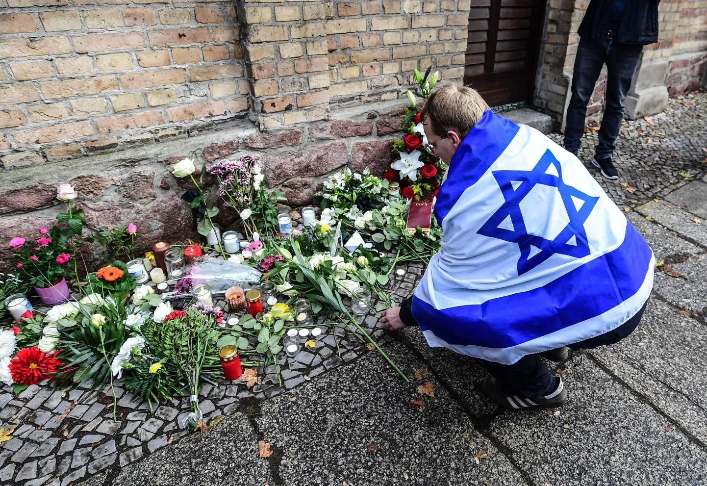 Iisraeli lipuga leinaja mälestamas kolmapäeval Saksamaal Halle linnas paremäärmusliku terroristi käe läbi hukkunud kaht inimest.