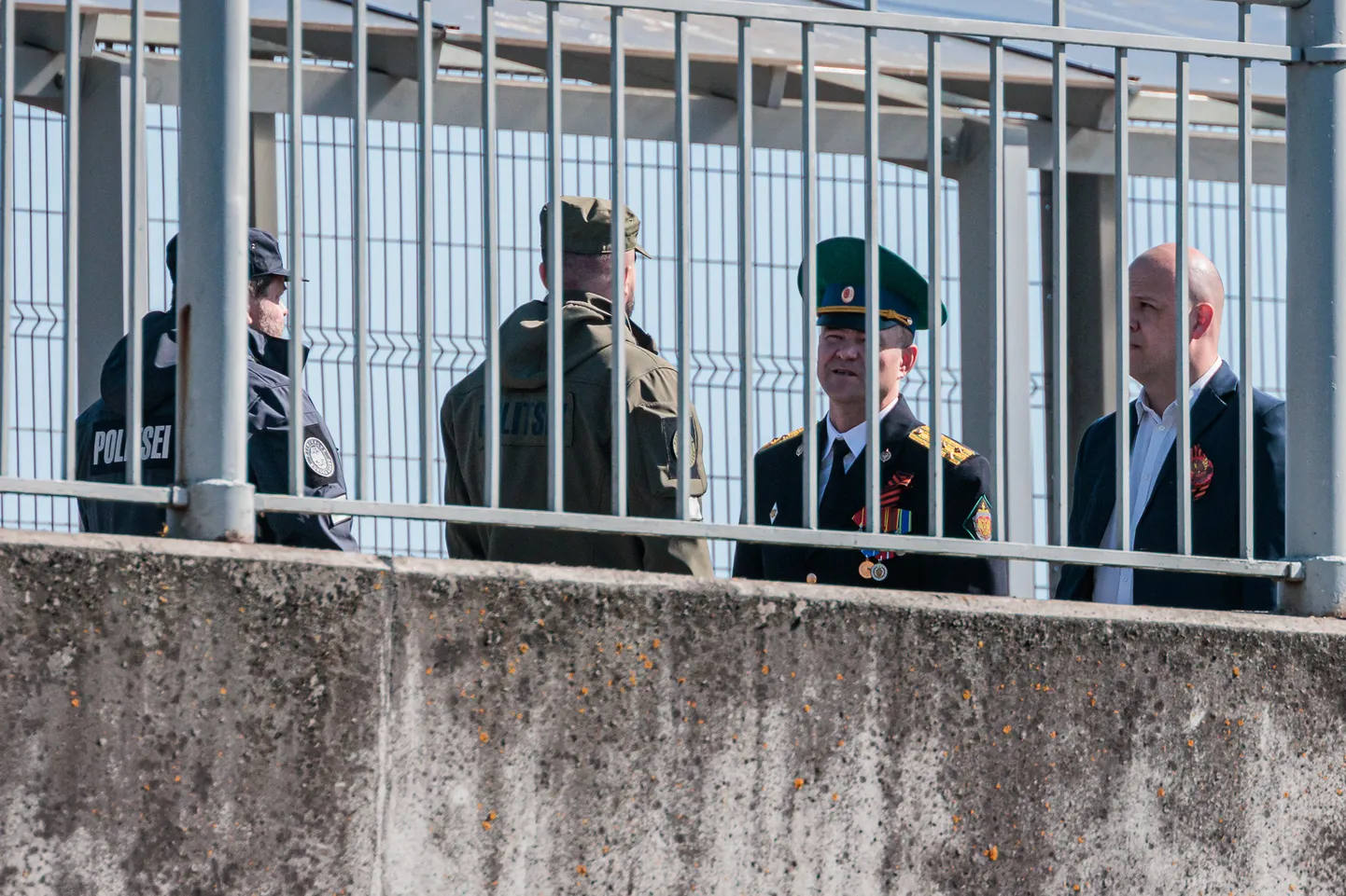 Eesti ja Vene piirivalvurid vaidlemas Narva sillal plakati üle, kus naaberriigi presidenti sõjakurjategijaks nimetatakse.
