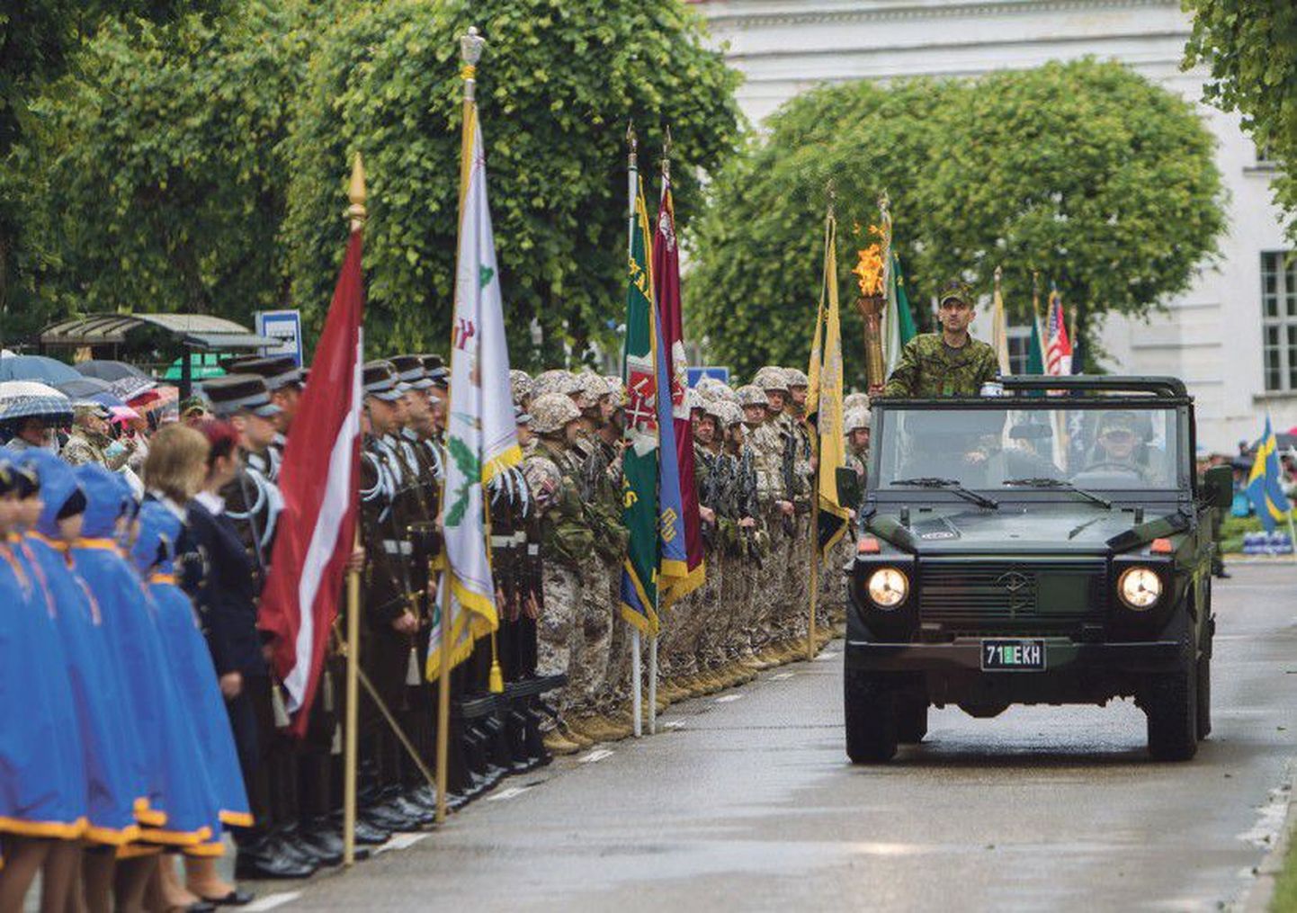 Mullune võidupüha paraad, kus võis kõrvuti seismas näha kodutütreid, Läti ja Ameerika Ühendriikide sõdureid.