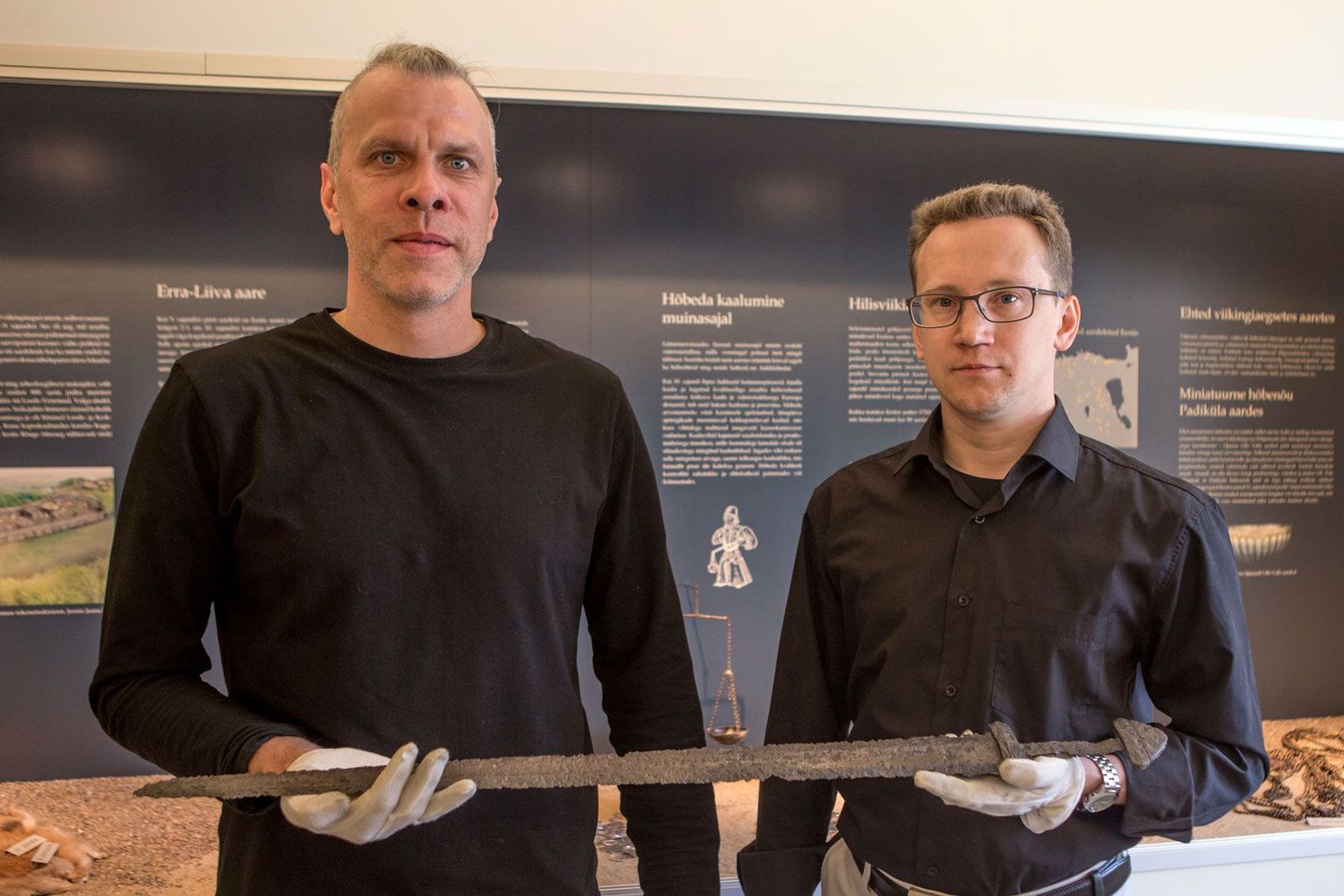 Arheoloogid Mauri Kiudsoo (vasakul) ja Priit Lätti viikingiaegse mõõgaga, mida tuli konserveerimiseks kolm kuud järjest keeta.