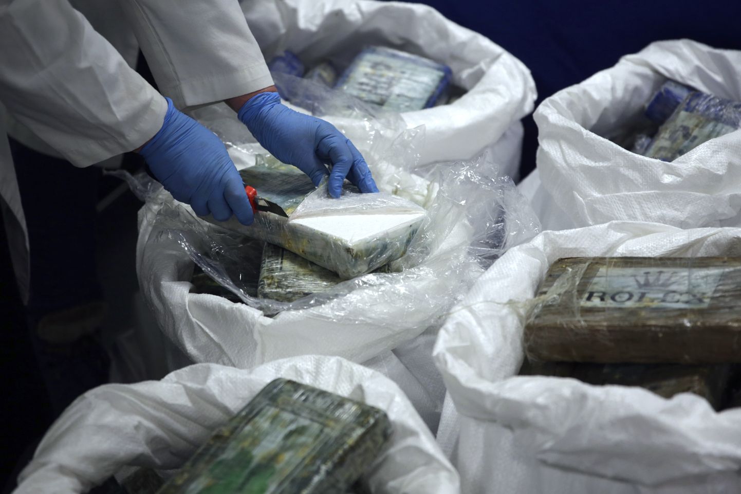 Portugali politseinik avab kokaiini pakke.