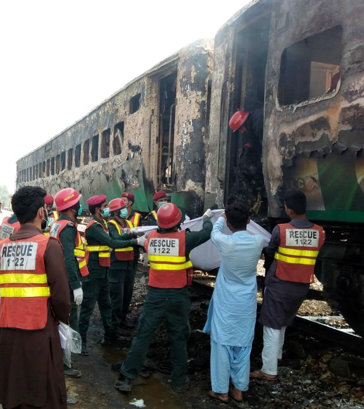 Päästetöötjad toomas surnukehi välja söestunud reisirongist Rahim Yar Khani lähistel Pakistanis. 