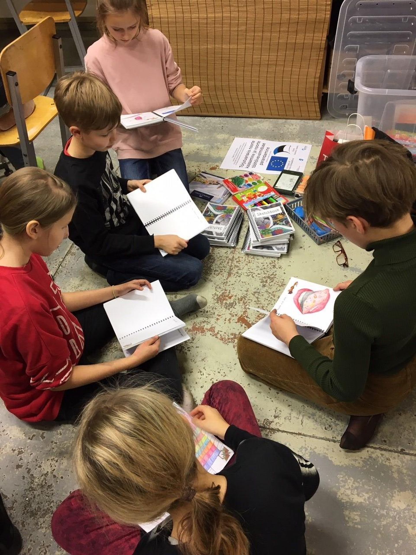 Pärnu kunstikooli õpilased tutvuvad visandiraamatutega.