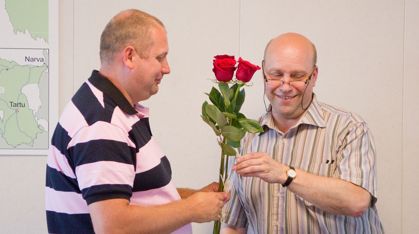 ROOSIDEGA ASI AMETLIKUKS: Volikogu esimees Urmas Lehtsalu (paremal) ulatab vastsele vallavanemale Andres Tinnole kolm suurt punast roosi. Foto: Alar Truu