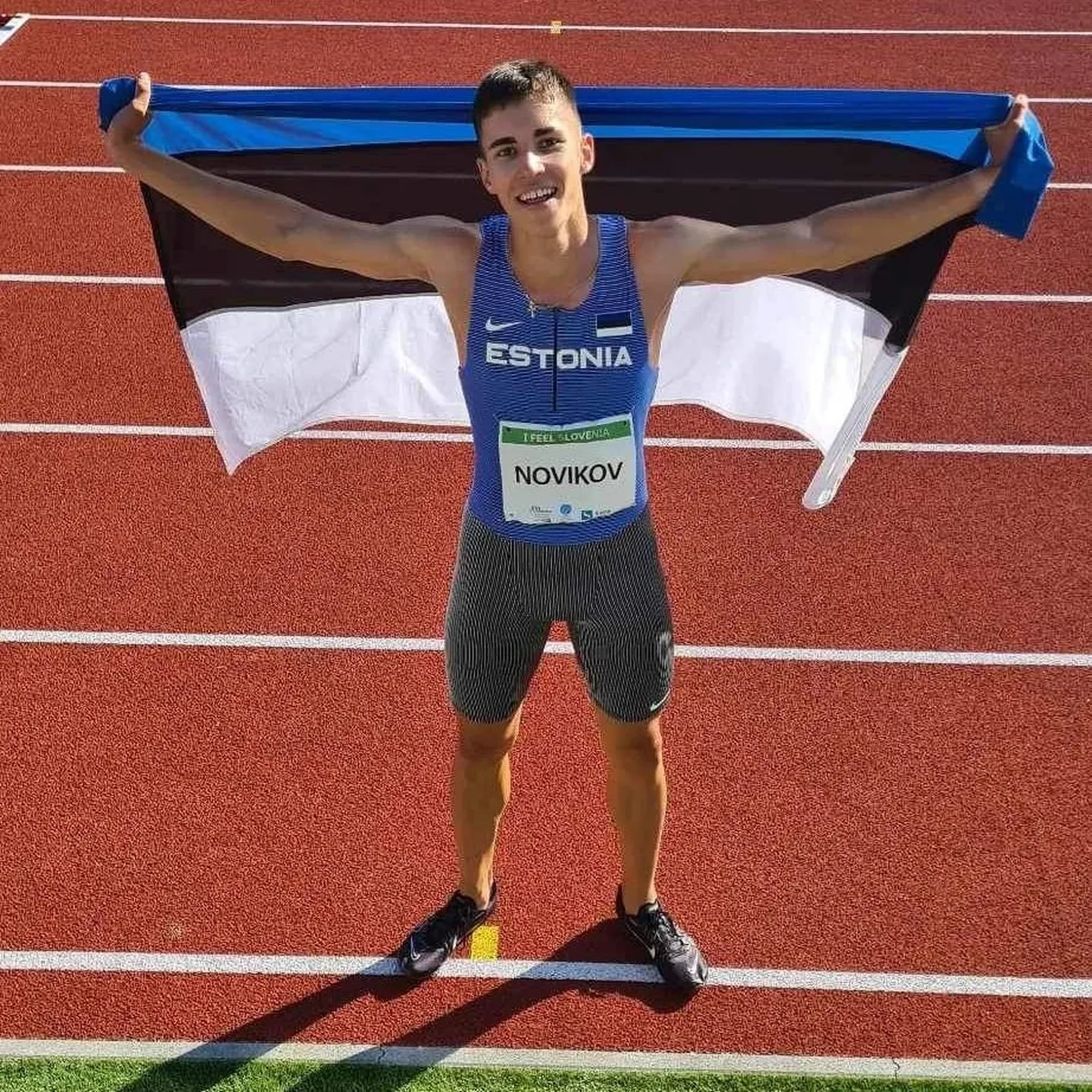 Радующийся бронзовой медали Савва Новиков после забега на стадионе "Марибора" поднял за плечами сине-черно-белый флаг.