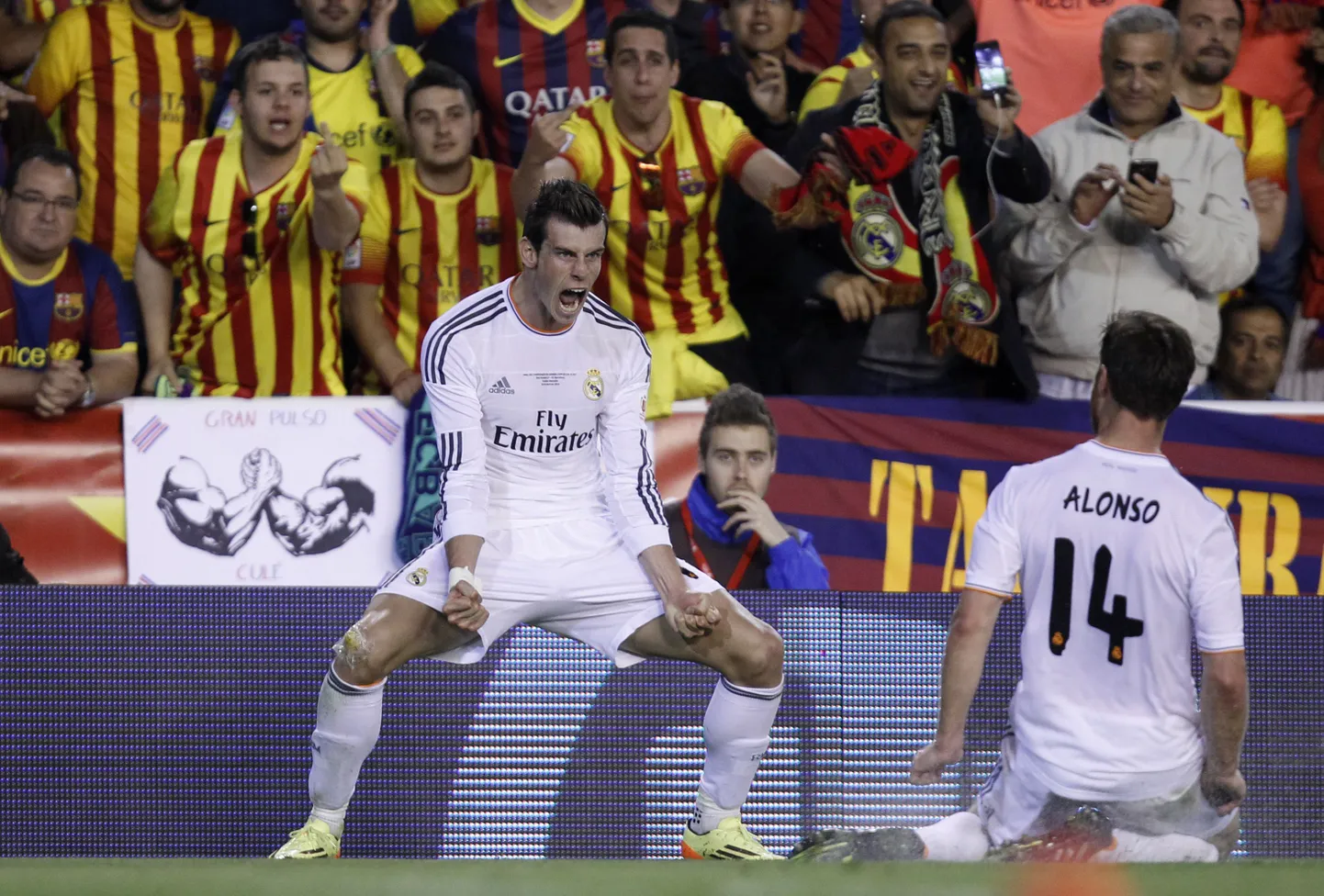 Karikafinaalis võiduvärava löönud Gareth Bale tähistab Barcelona fännide ees, kels demonstreerivad ilmekalt oma arvamust.