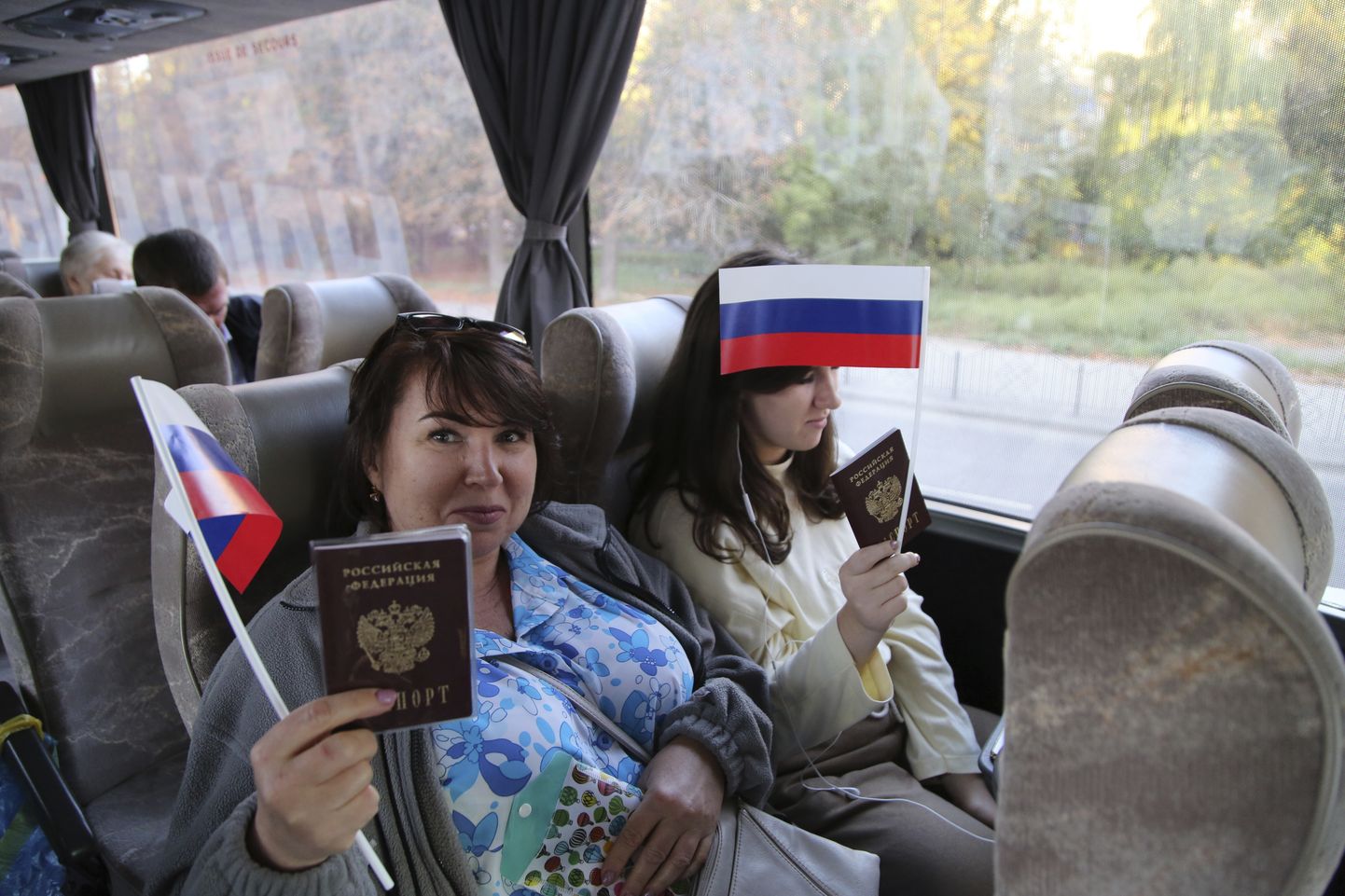 Donetskis elavad Venemaa kodanikud lehvitamas Venemaa lippudega ja näitamas Vene passe 17. septembril 2021, olles teel Venemaale, kus nad läksid andma oma häält parlamendivalimistel.