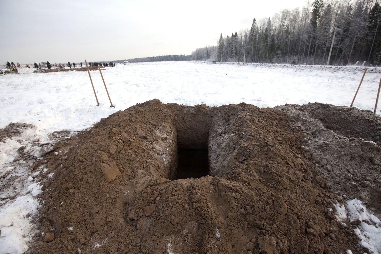 Valmiskaevatud auk ootab järjekordset kirstu Permi tuleõnnetuseohvri surnukehaga.