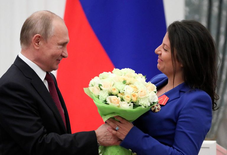Путин вручает цветы главному редактору российского телеканала RT Маргарите Симоньян после награждения ее «Орденом Александра Невского» во время церемонии в Кремле в Москве в 2019 году.