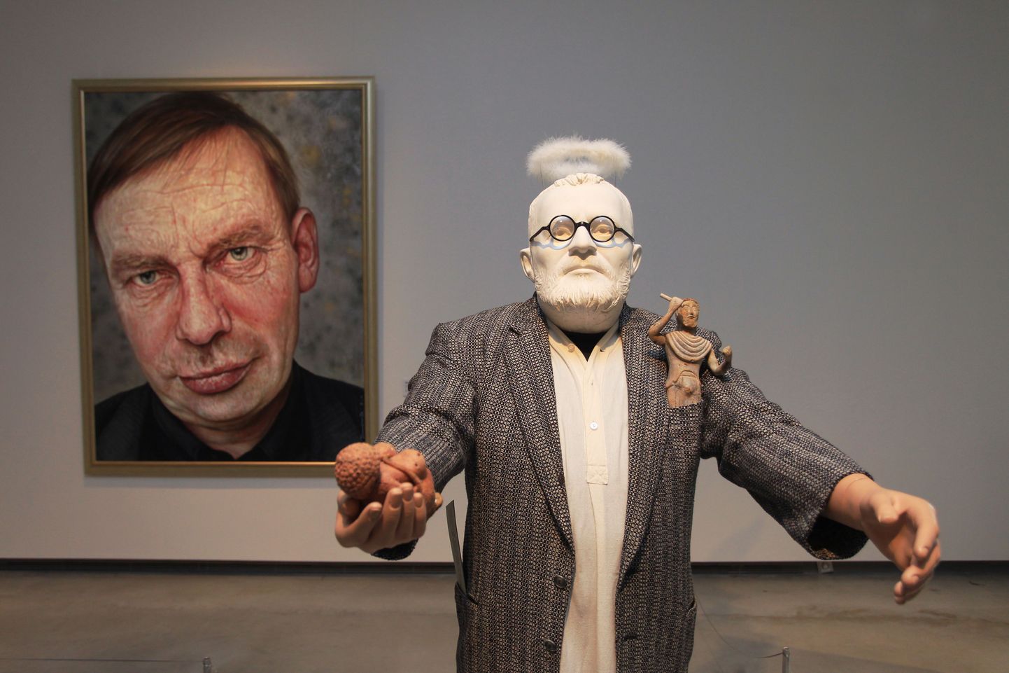 Esiplaanil osa Tiiu Kirsipuu installatiivsest portreeskulptuurist «Hardi Volmer – animaator» (kips, tekstiil, plast jm, elusuurus, 2015). Seinal Ilmar Kruusamäe «Ants oli aus … (kunstiteadlase Ants Juske portree)» aastast 2004 (õli lõuendil, 200 x 150 cm).