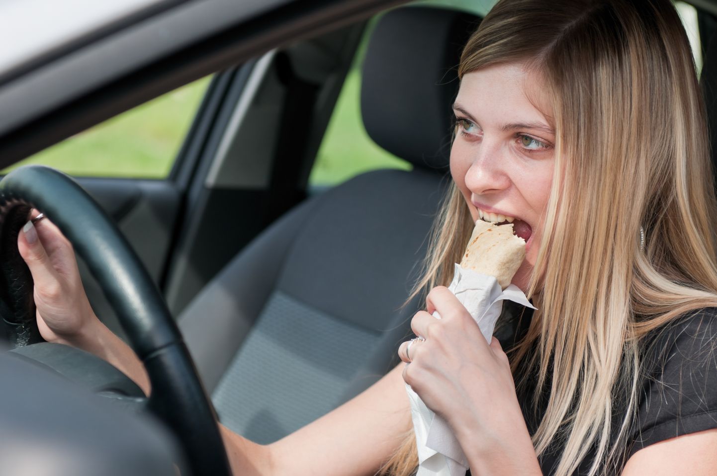 Naine sööb autos.