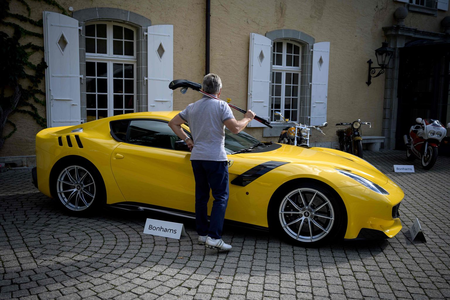 Mees vaatab Šveitsis välja pandud Ferrari sportautot.