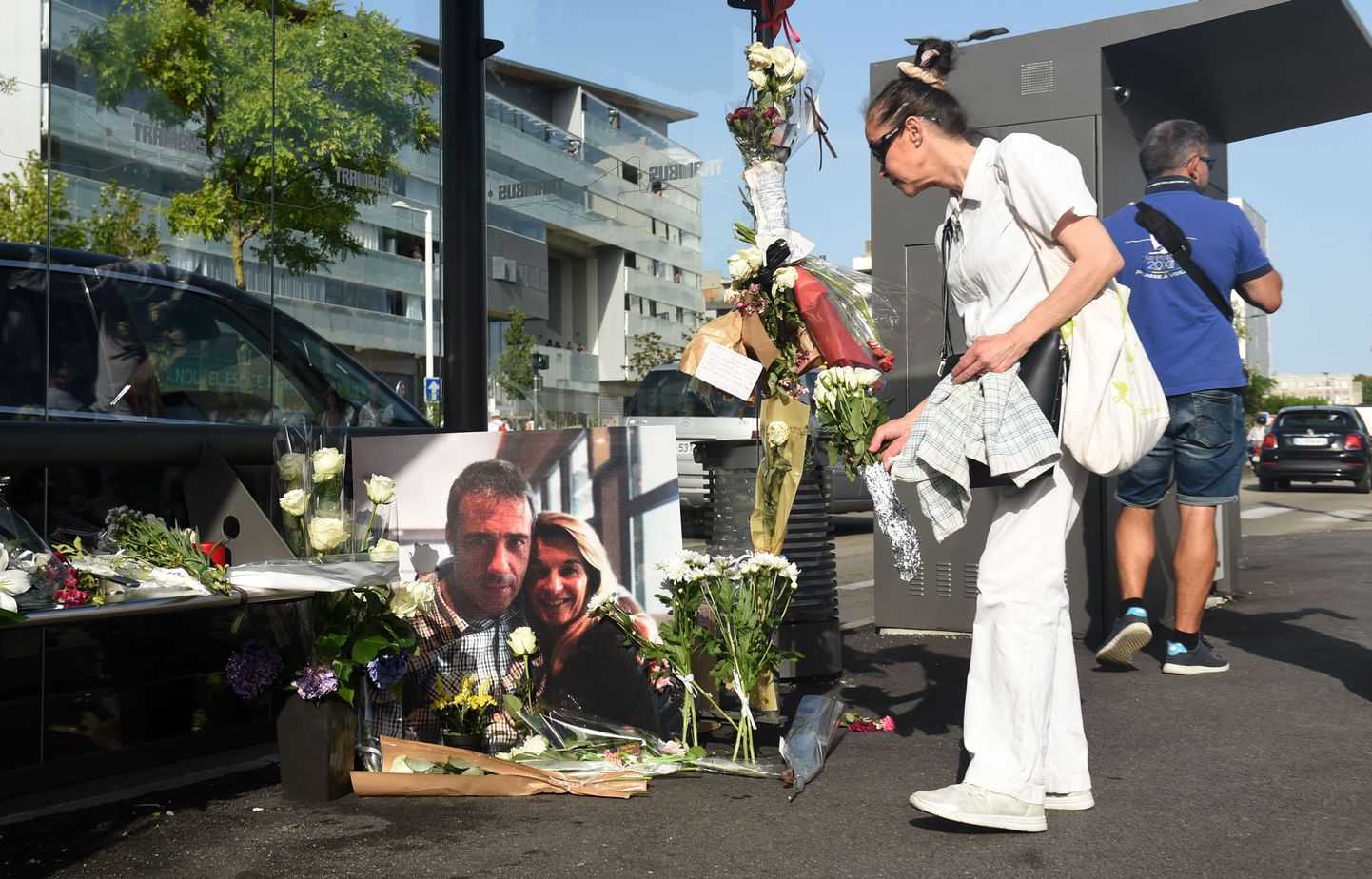 Люди несут цветы к портрету убитого водителя автобуса.