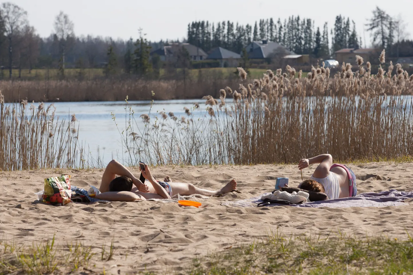 Esimesed päevitajad järve ääres.