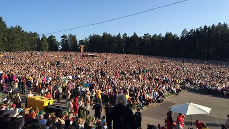 Skolēnu dziesmu un deju svētku dalībnieki un apmeklētāji dzied Latvijas himnu