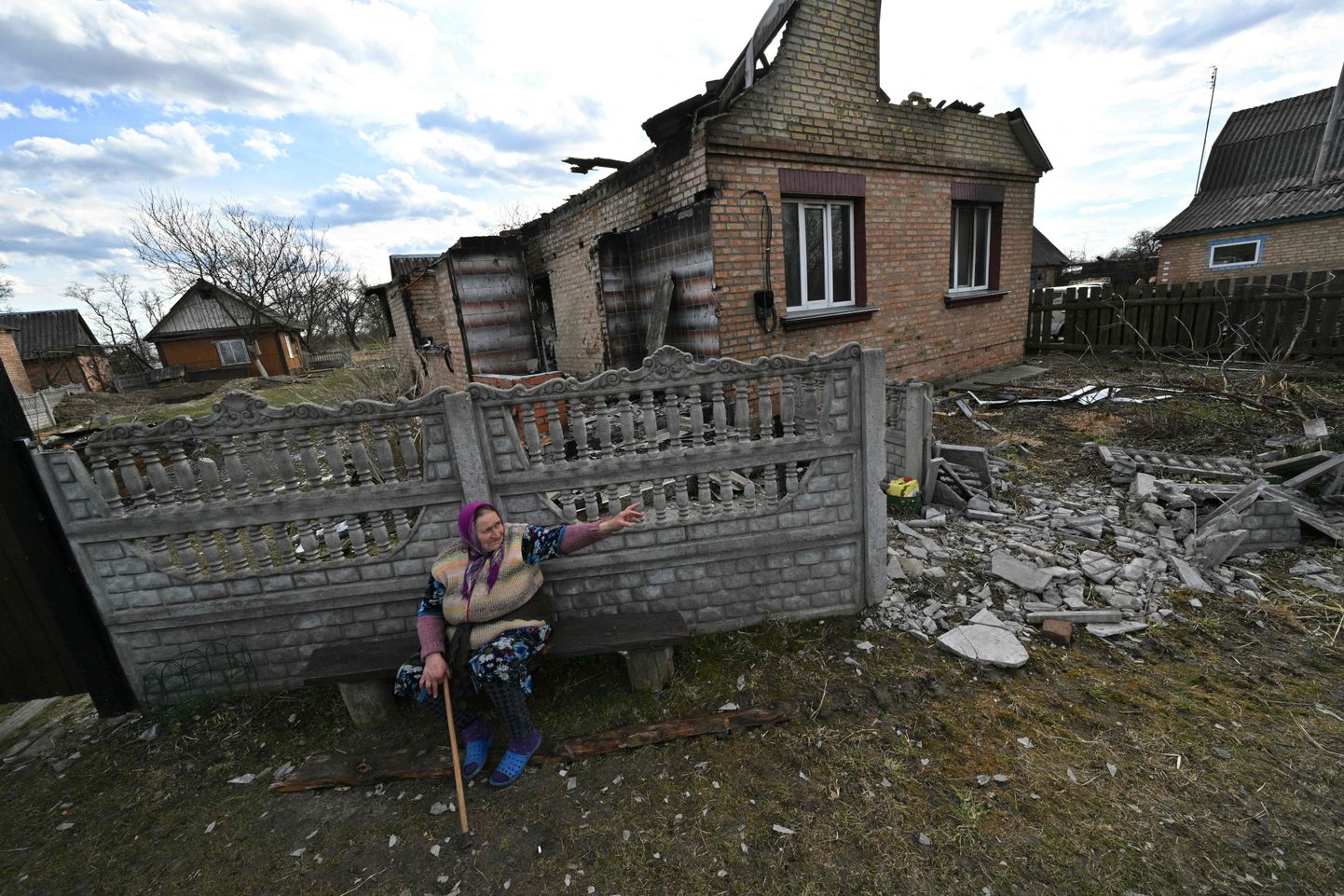 Külanaine 7. aprillil 2022 Ukraina põhjaosas Obuhhovõtšis hävitatud maja ees istumas ja olukorda kirjeldamas.