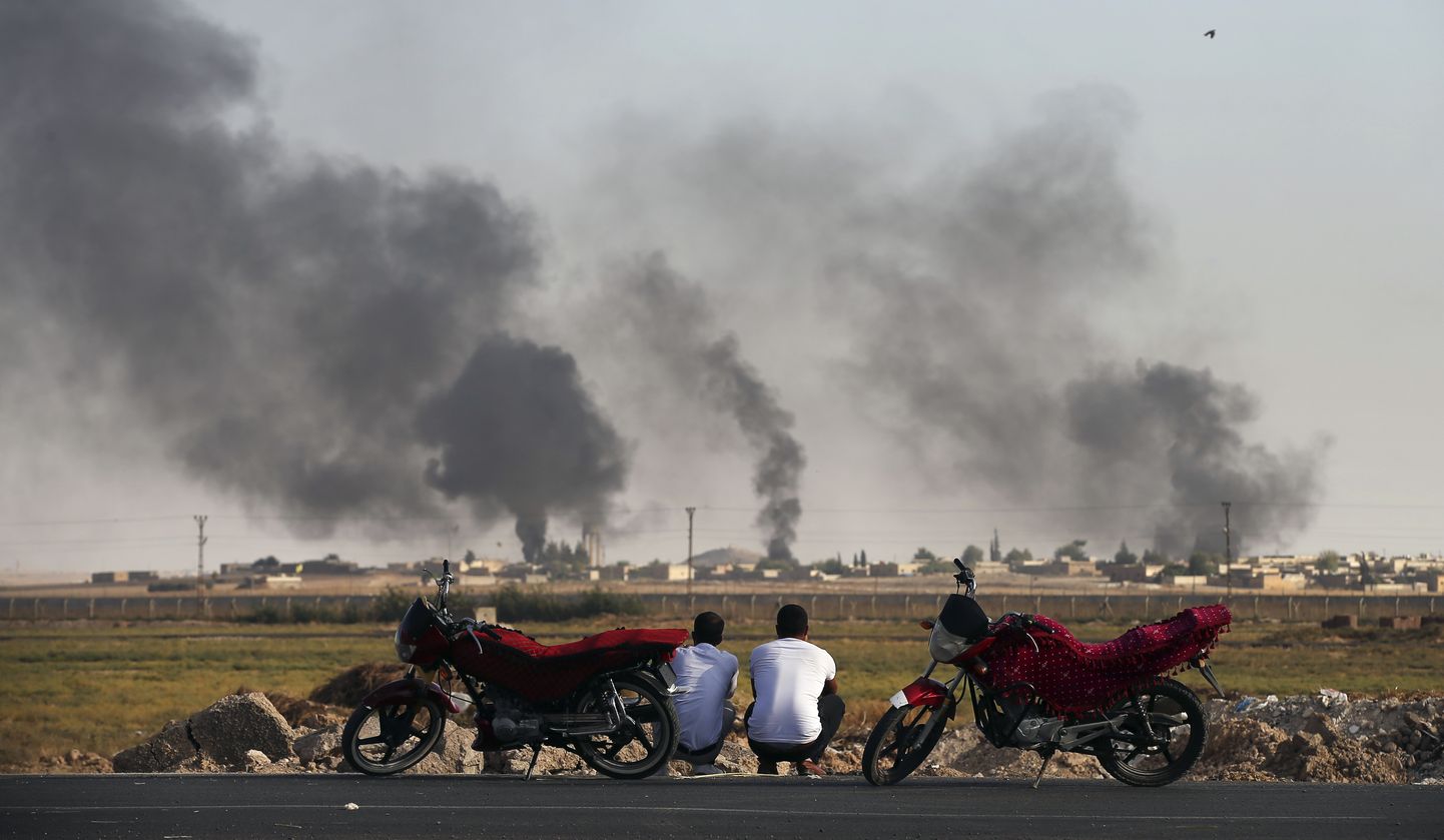 Mehed vaatamas Türgis Akçakale linnas üle piiri Süüriasse, kus kõrgub sõjategevusest alguse saanud suits.