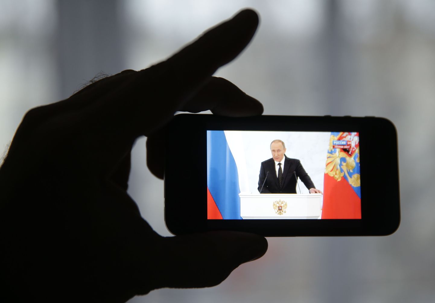 Kodanik vaatab Vladimir Putini esinemist nutiseadmega.