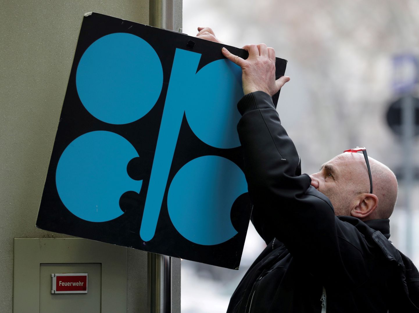 Mees parandab OPECi peakorteri küljes olevat naftakartelli logo.