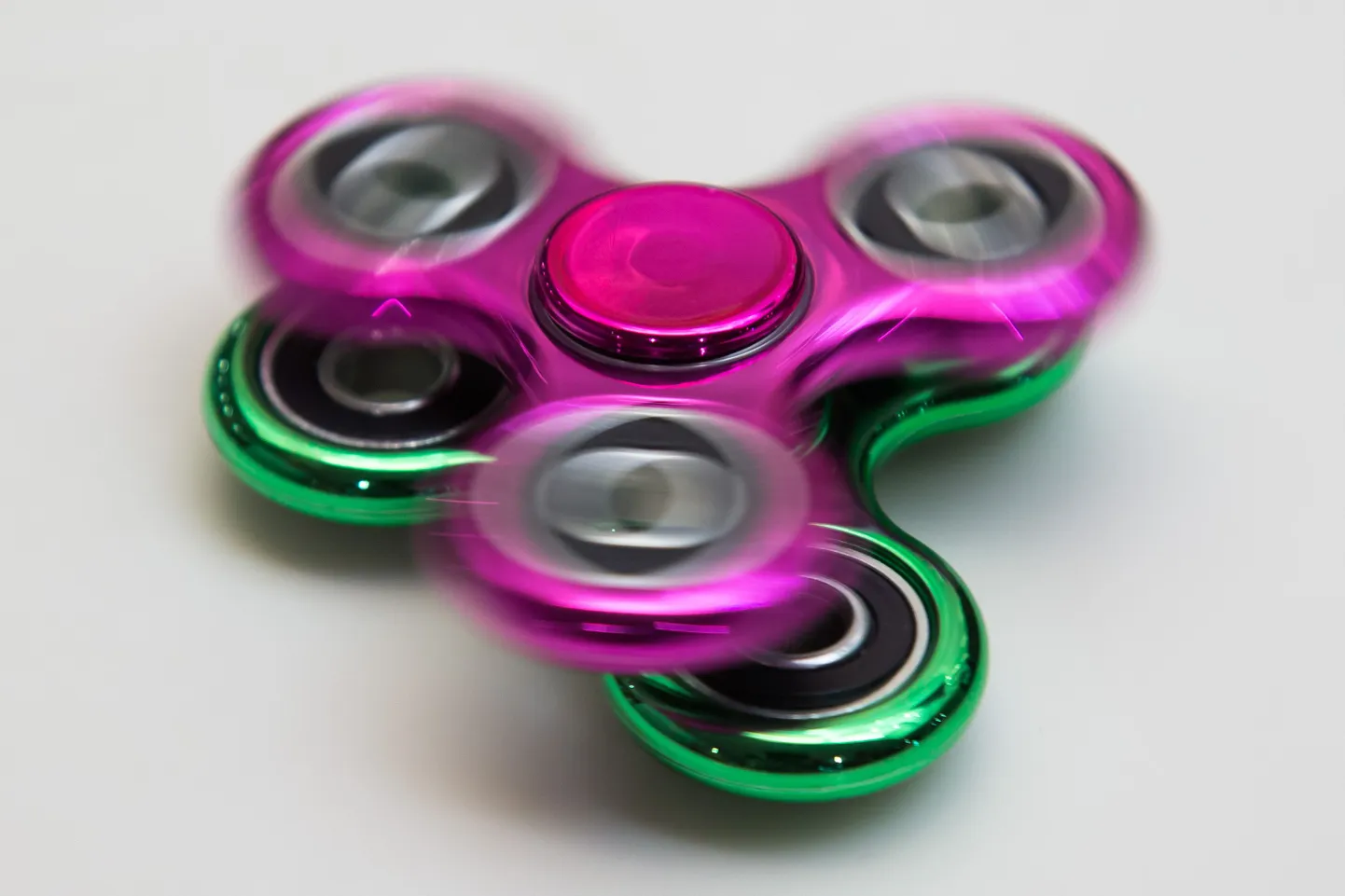 Kaks fidget spinner'it üksteise peal keerlemas.