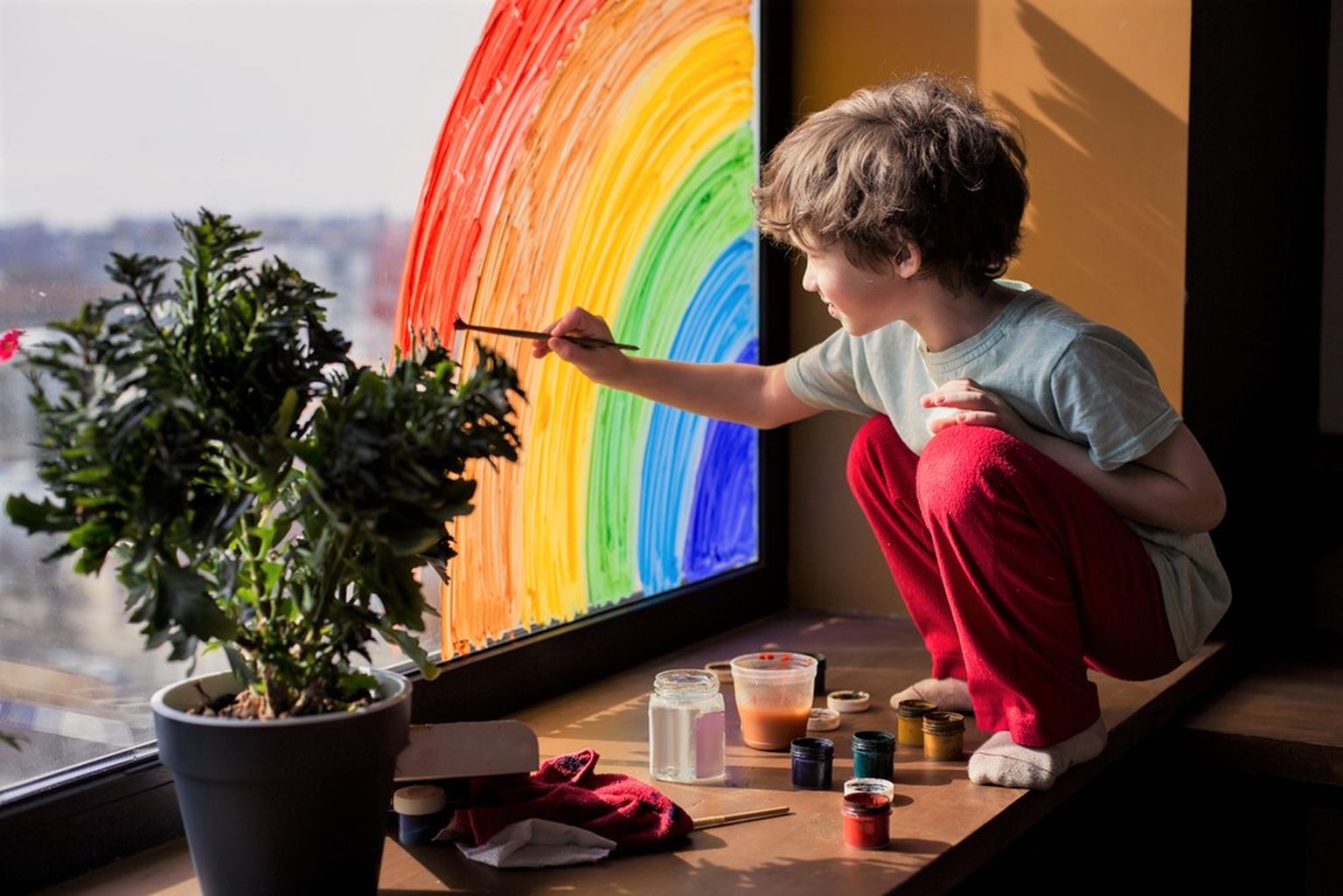 Laps maalib aknale vikerkaart. Pilt on illustratiivne.
