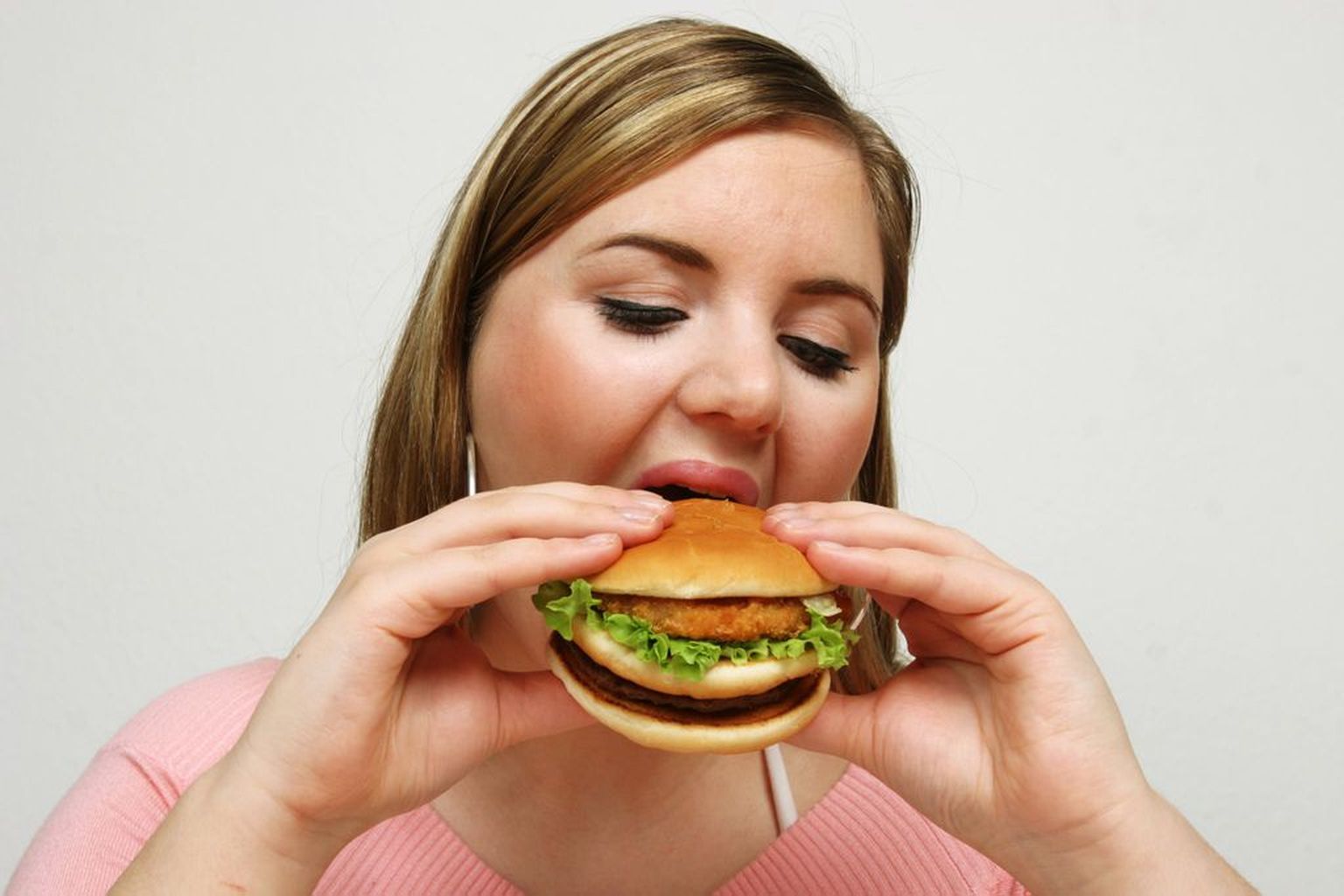 Девушка ест гамбургер. Иллюстративное фото.