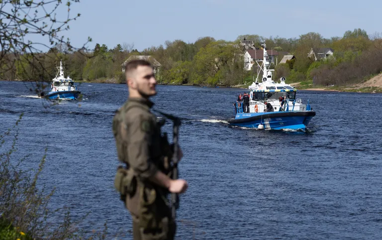 Сотрудник PPA дежурит на берегу реки Наровы во время перемещения вдоль границы с Россией пограничных катеров с президентами Эстонии и Исландии на борту. Речная прогулка Алара Кариса и Гвюдни Йоуханнессона состоялась ровно за неделю до инцидента, когда сотрудники ФСБ демонтировали и увезли световые буи Эстонии.