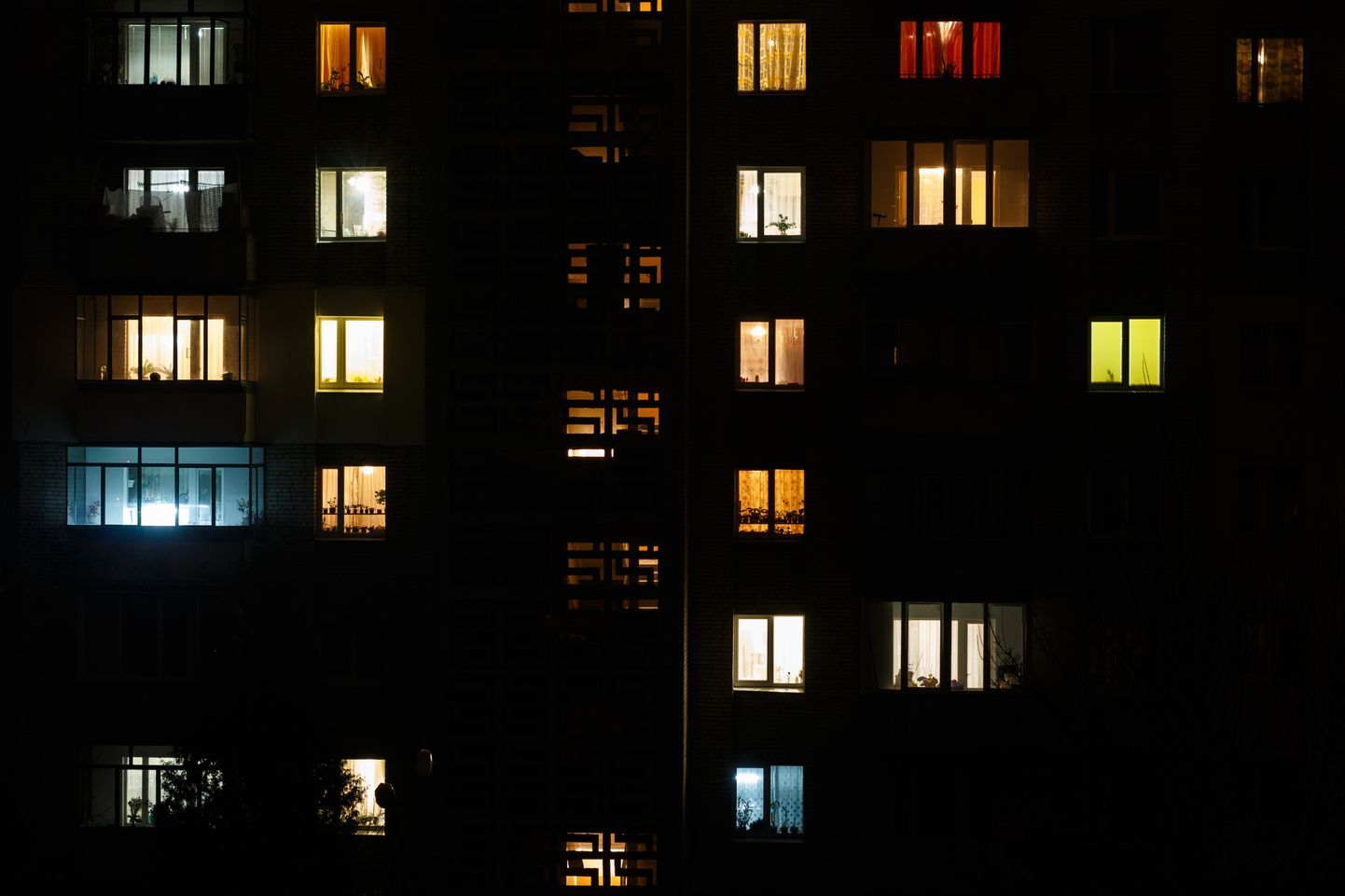 Освещенные окна многоквартирного дома. Снимок иллюстративный.